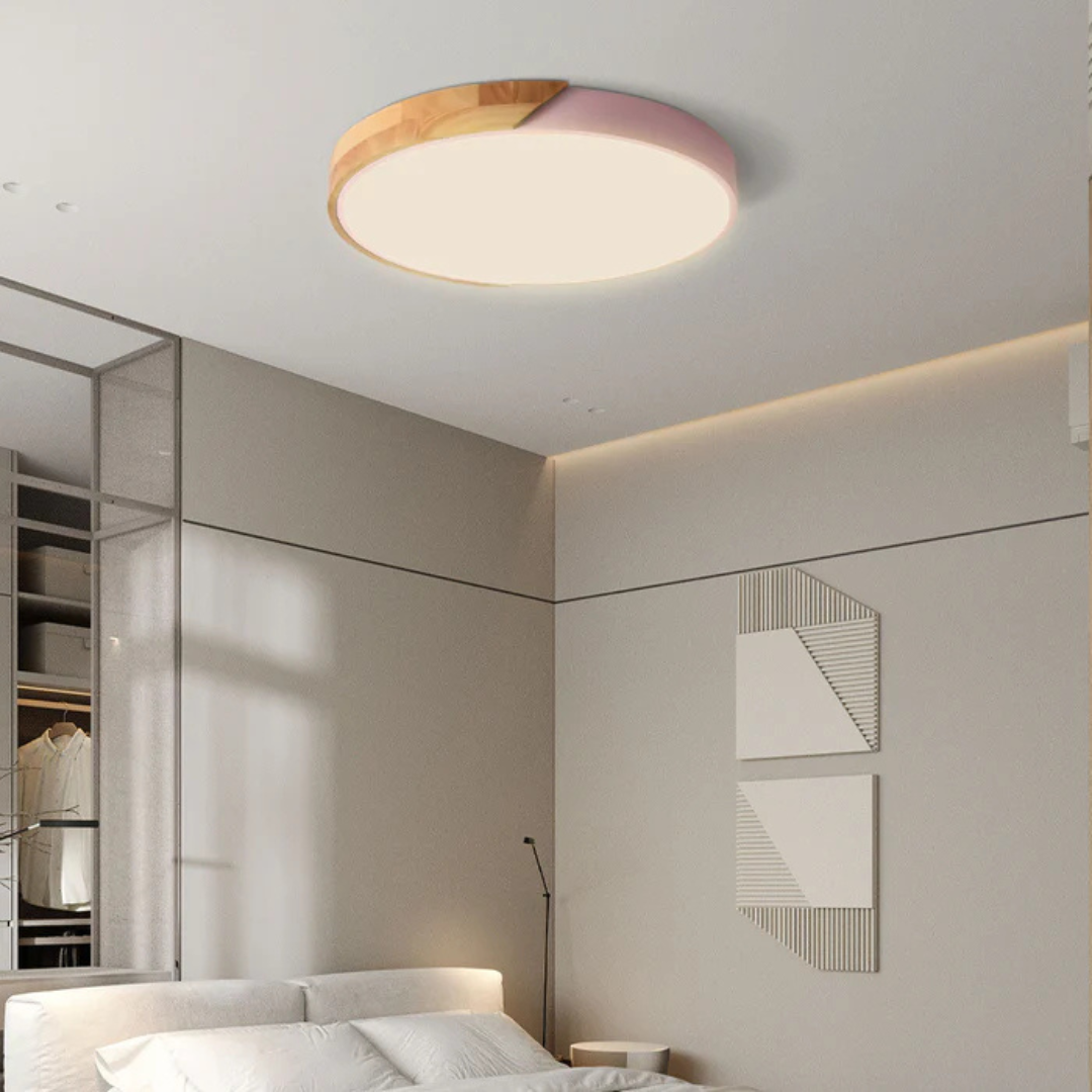 Pink and wood round ceiling light in a softly lit bedroom with a bed and wall art 5
