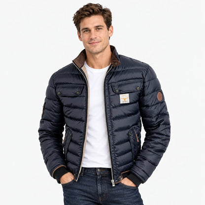 Model wearing the navy quilted jacket open over a white t-shirt and dark jeans, hands in pockets 11