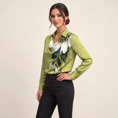 Model turned slightly sideways in a green satin blouse with large white flower print and black trousers 11