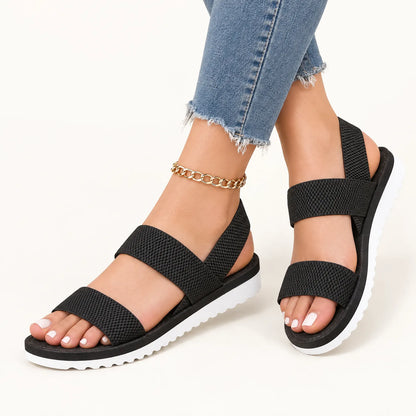 Black woven-strap sandals with white soles, worn with frayed jeans and a gold chain anklet 11