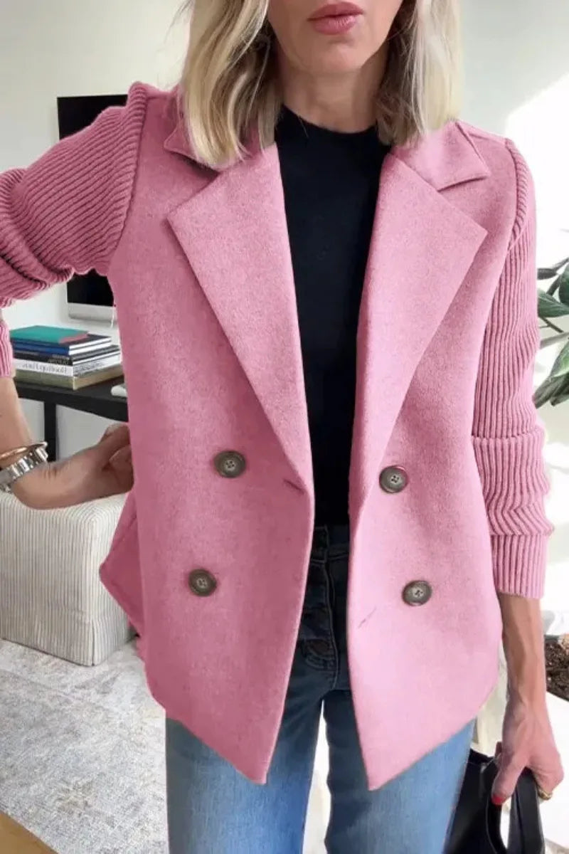 Close-up of pink double-breasted jacket on model, showing notch lapels and ribbed knit sleeves 12