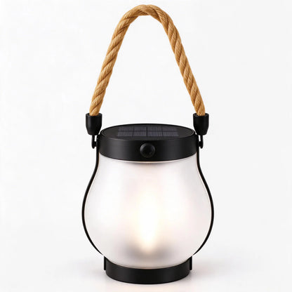 Frosted glass lantern giving off a soft warm white glow, with a black solar top and rope handle 12
