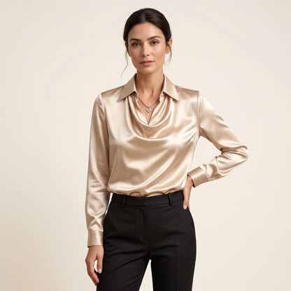 Model in a champagne satin blouse with draped collar, black trousers and heart pendant, hand on hip 12