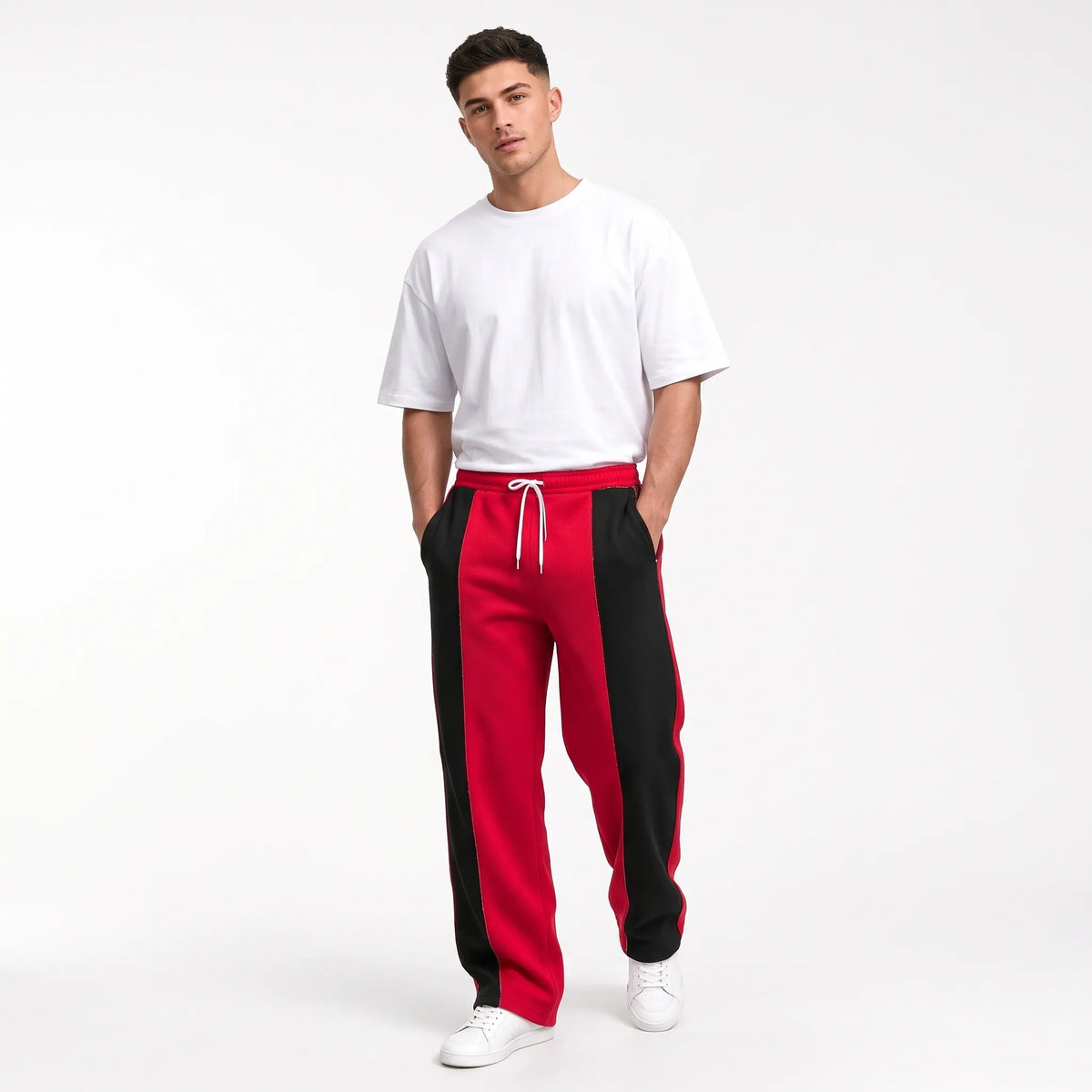Studio shot of a model in red sweatpants with black side panels and a white tee 12
