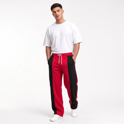 Studio shot of a model in red sweatpants with black side panels and a white tee 12