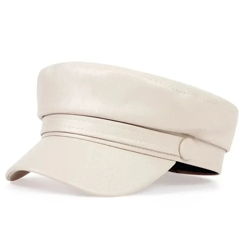 Cream faux leather baker boy hat, three-quarter view, showing the covered button and stitched band 12