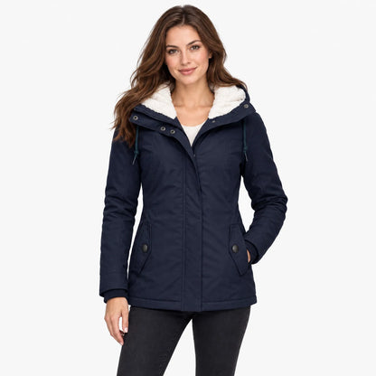 Model with long brown hair wears the navy jacket over a cream jumper, one hand in pocket 12