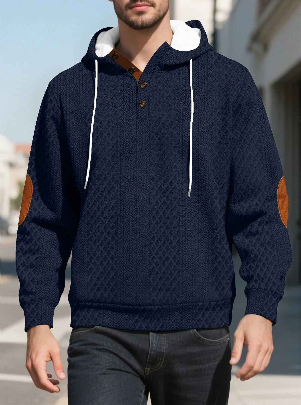 Model walking outdoors in a navy diamond-textured hoodie, front view with tan elbow patches and buttons 13