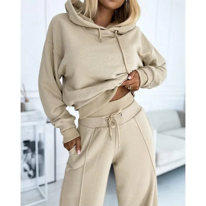 Close-up of the beige hoodie and ribbed-waist trousers, model's hand tucked into the pocket 13
