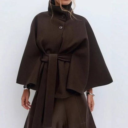 Dark brown cape jacket with silver bangles, high collar buttoned and belt tied at the waist 13