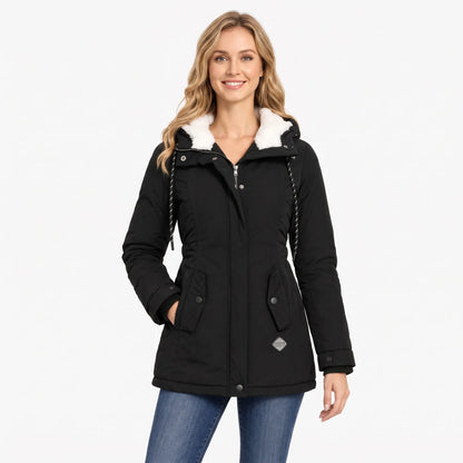 Smiling model in the black jacket, one hand in pocket, standing in jeans against a plain background 13