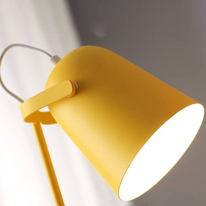 Close-up of the yellow lamp's bucket shade glowing, showing the matte metal finish and the pivoting arm. 2
