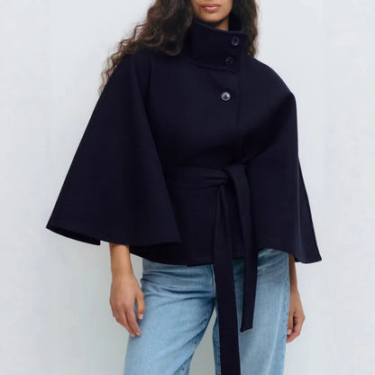 Navy cape jacket worn with blue jeans, cropped view of the collar, buttons and tied belt 14