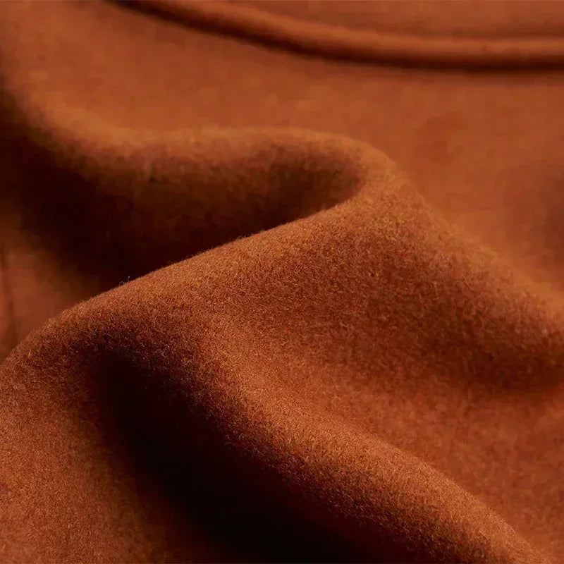 Close-up of soft, brushed tan wool-blend fabric gathered in folds, showing its fine surface texture 14