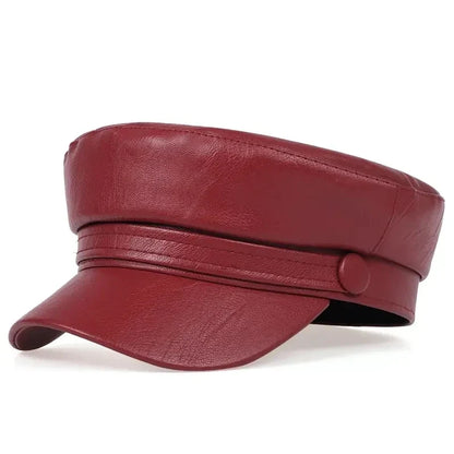 Burgundy red baker boy hat in faux leather, three-quarter view with the button on the band 14