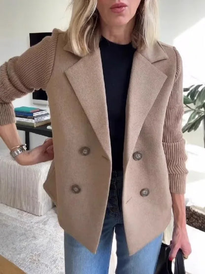 Taupe double-breasted jacket with ribbed sleeves, worn with hand on hip over black top and jeans 15