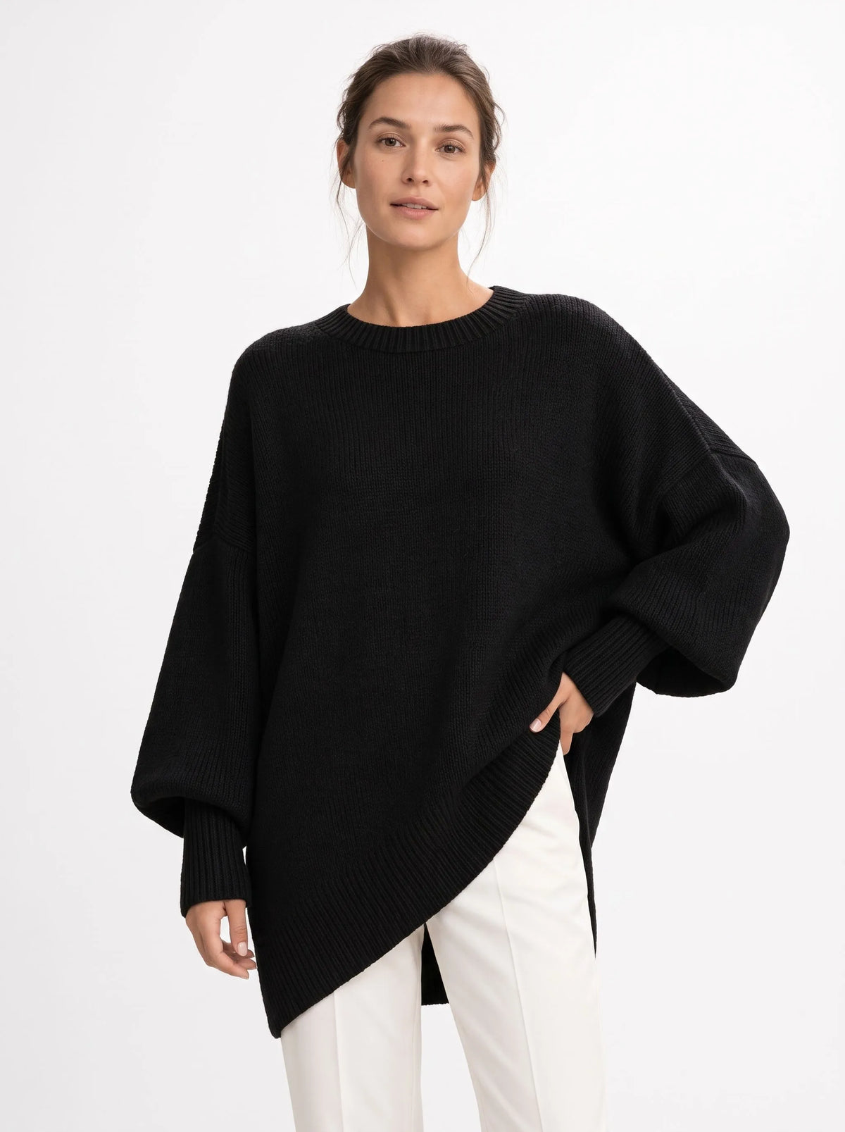Studio shot of the black jumper with a hand on the hip, showing ribbed hem and balloon sleeves 15
