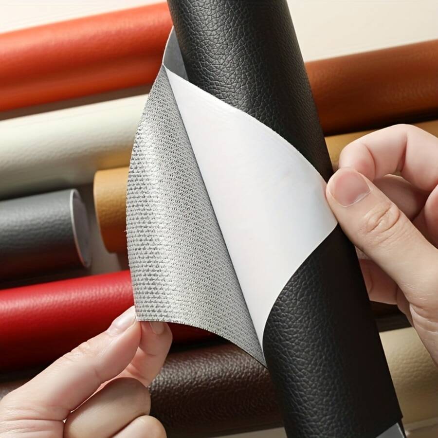 Hands peel the backing from a black roll of leather-grain patch, with rolls in other colours behind 1