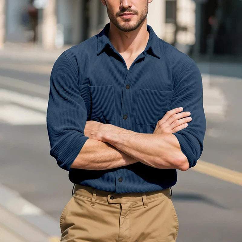 Model wearing the navy blue shirt with arms crossed on a sunlit street 16