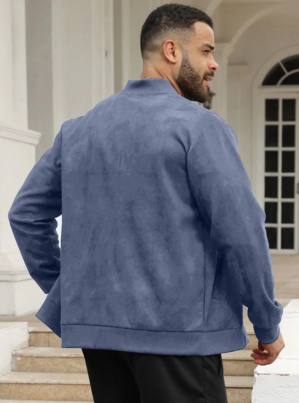 Back view of a man in the blue jacket on steps in front of white pillars 16