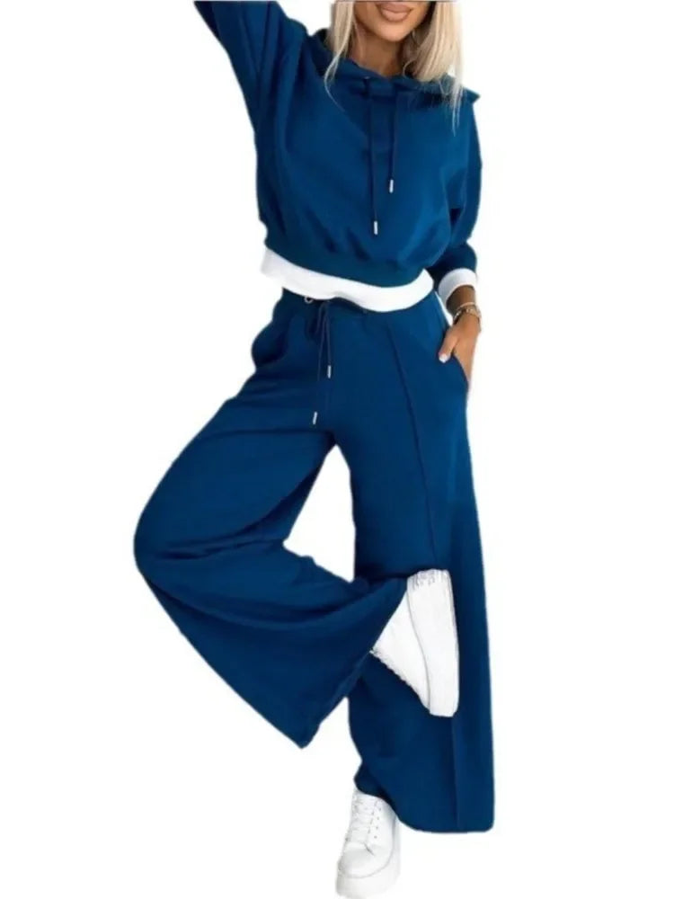 Blue hooded set on a plain white background, model with raised arm and one leg lifted 16