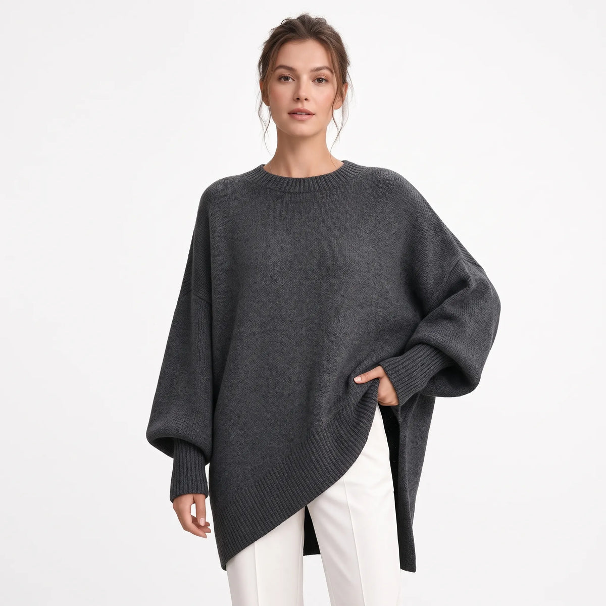 Studio shot of the dark grey jumper with ribbed cuffs and hem, worn with white trousers 16
