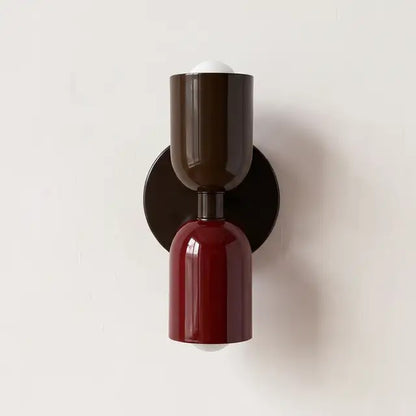 Wall lamp with a dark brown upper shade and glossy burgundy lower shade on a black round backplate. 24