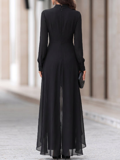 Back view of the black tunic and trousers, showing the centre zip, buttoned cuffs and sheer chiffon hem. 5