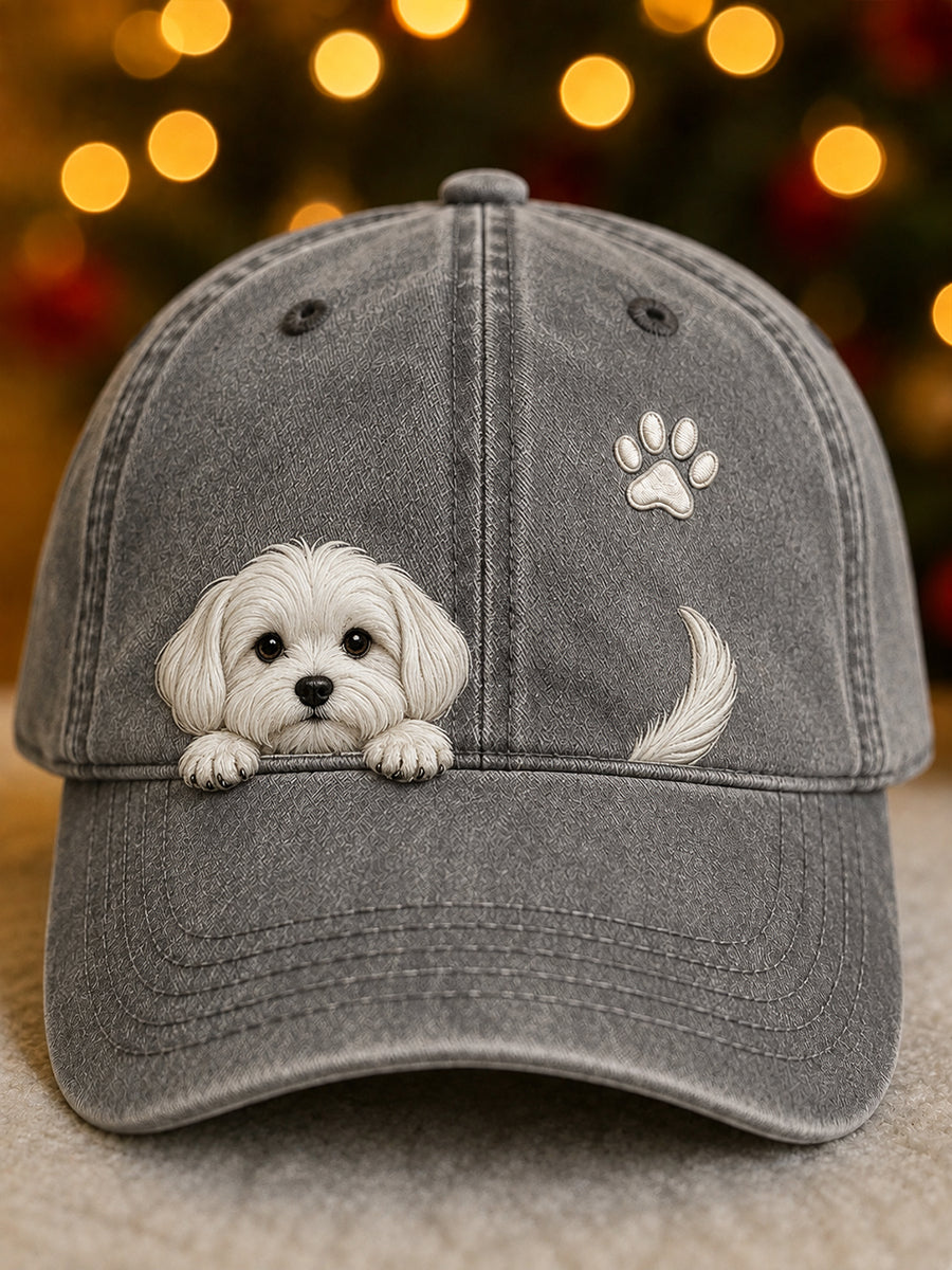 Front view of the cap in washed grey with a white puppy peeking over the peak, a paw print and tail. 4