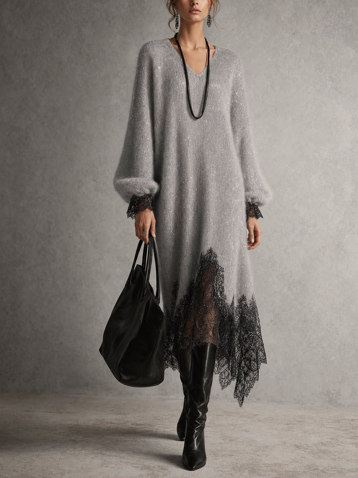Model wearing the grey dress full length with black boots and a black tote, front view 1
