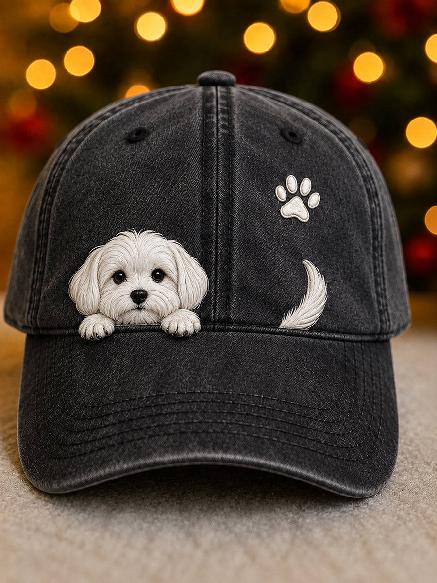 Front view of the cap in washed black with a white puppy peeking over the peak, a small paw print and tail. 3