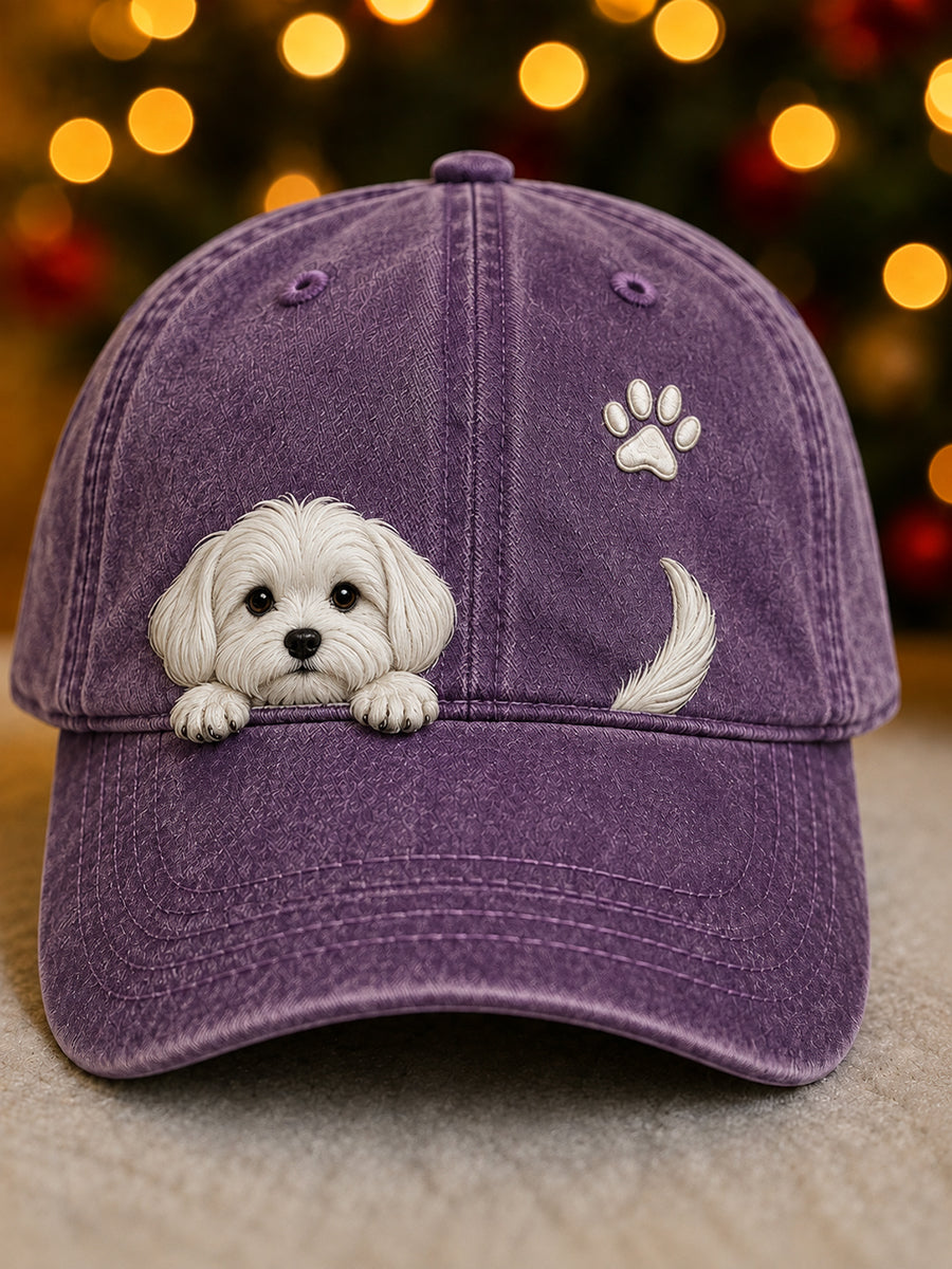 Front view of the cap in washed purple with a white puppy peeking over the peak, a paw print and tail. 7
