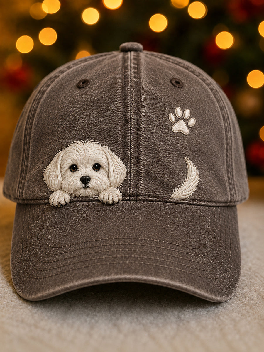 Front view of the cap in washed brown with a white puppy peeking over the peak, a paw print and tail. 6
