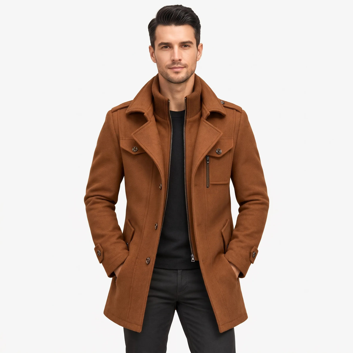 Man in the tan coat worn open over a black jumper, hands in pockets, against a pale backdrop 17