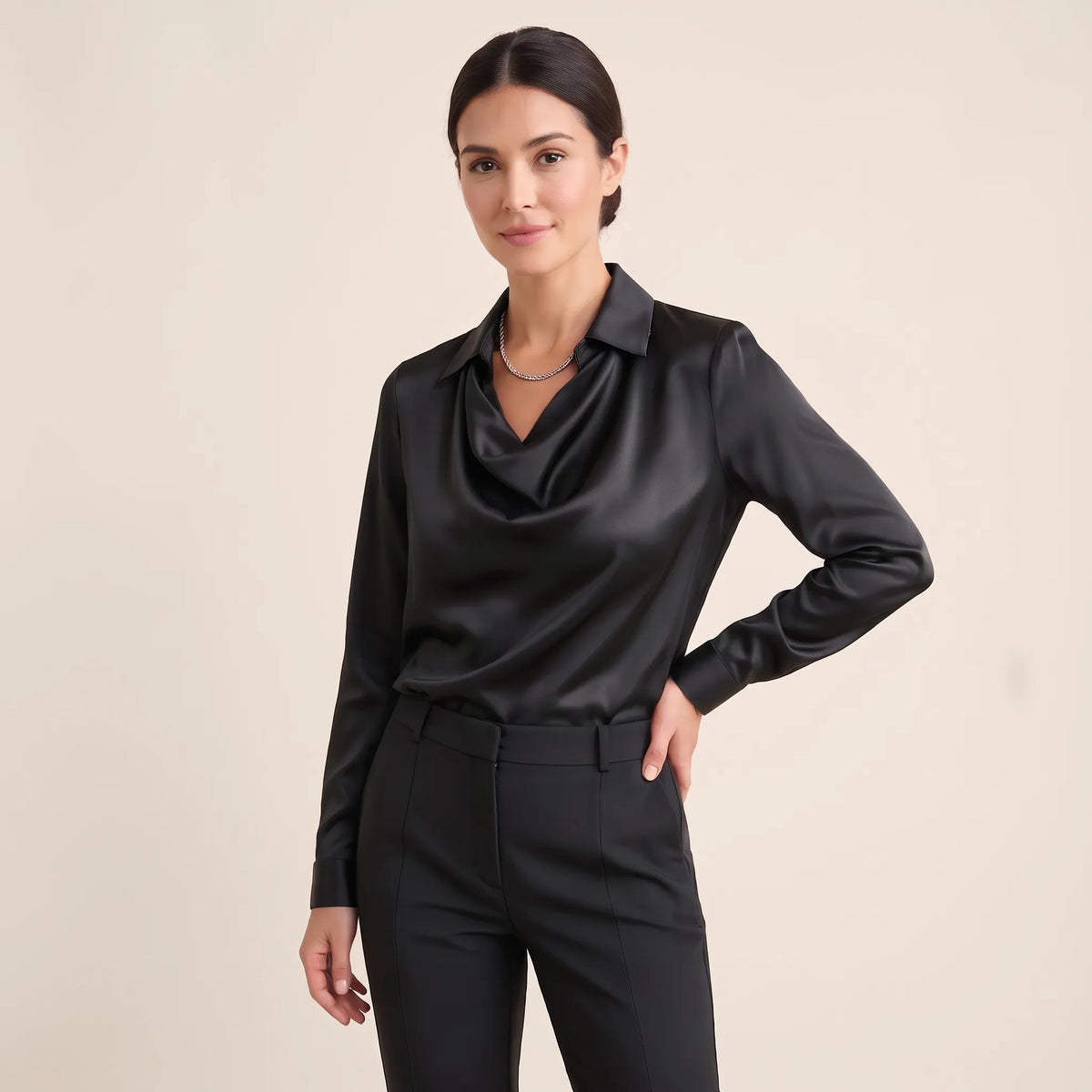 Model in a plain black satin blouse with draped neckline, black trousers and silver chain necklace 17