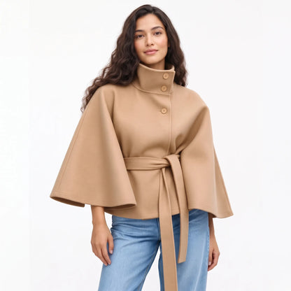 Studio shot of the camel cape jacket with jeans, tan buttons and a tied belt 18