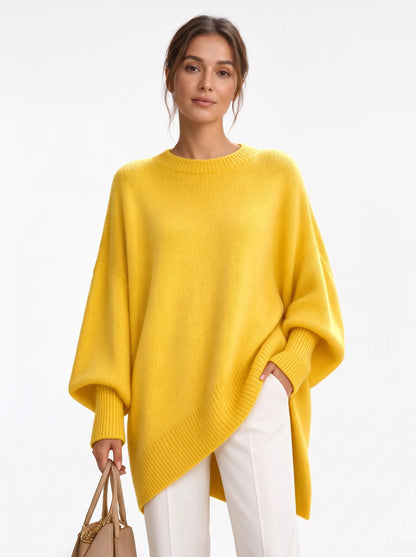 Studio shot of the bright yellow jumper, worn with white trousers while holding a beige handbag 18
