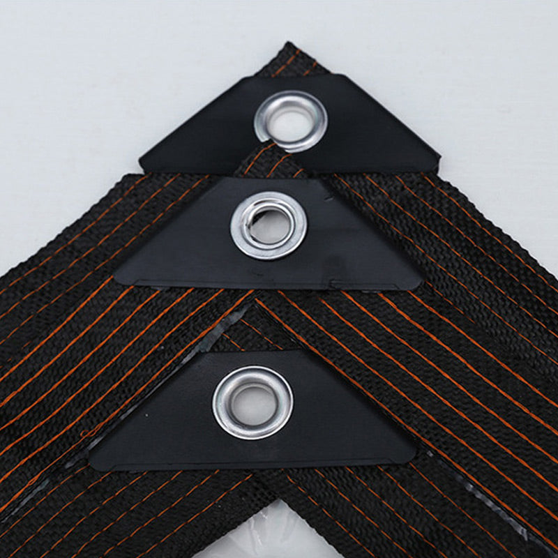 Close-up of three metal eyelets set in black reinforced corner patches on woven edging with orange stitching. 5
