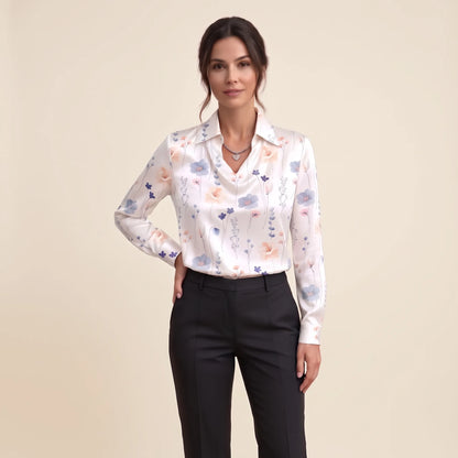 Model in a white satin blouse with pastel wildflower print, black trousers and a heart pendant 19