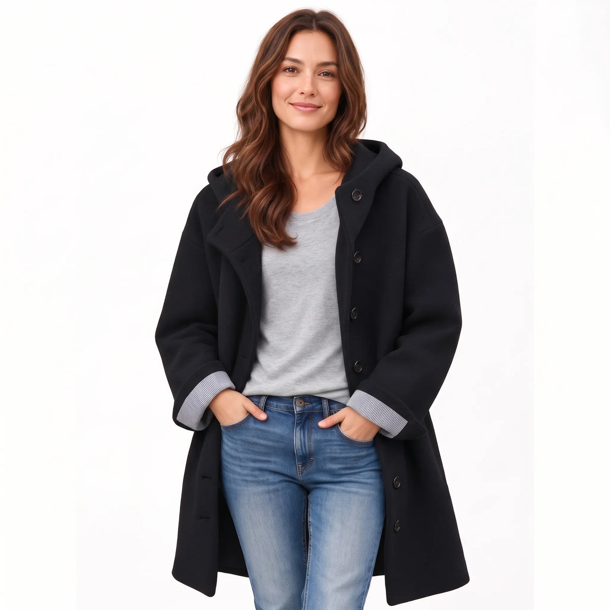Studio view of a model in the black hooded coat, striped cuffs visible, over a grey top and jeans 19