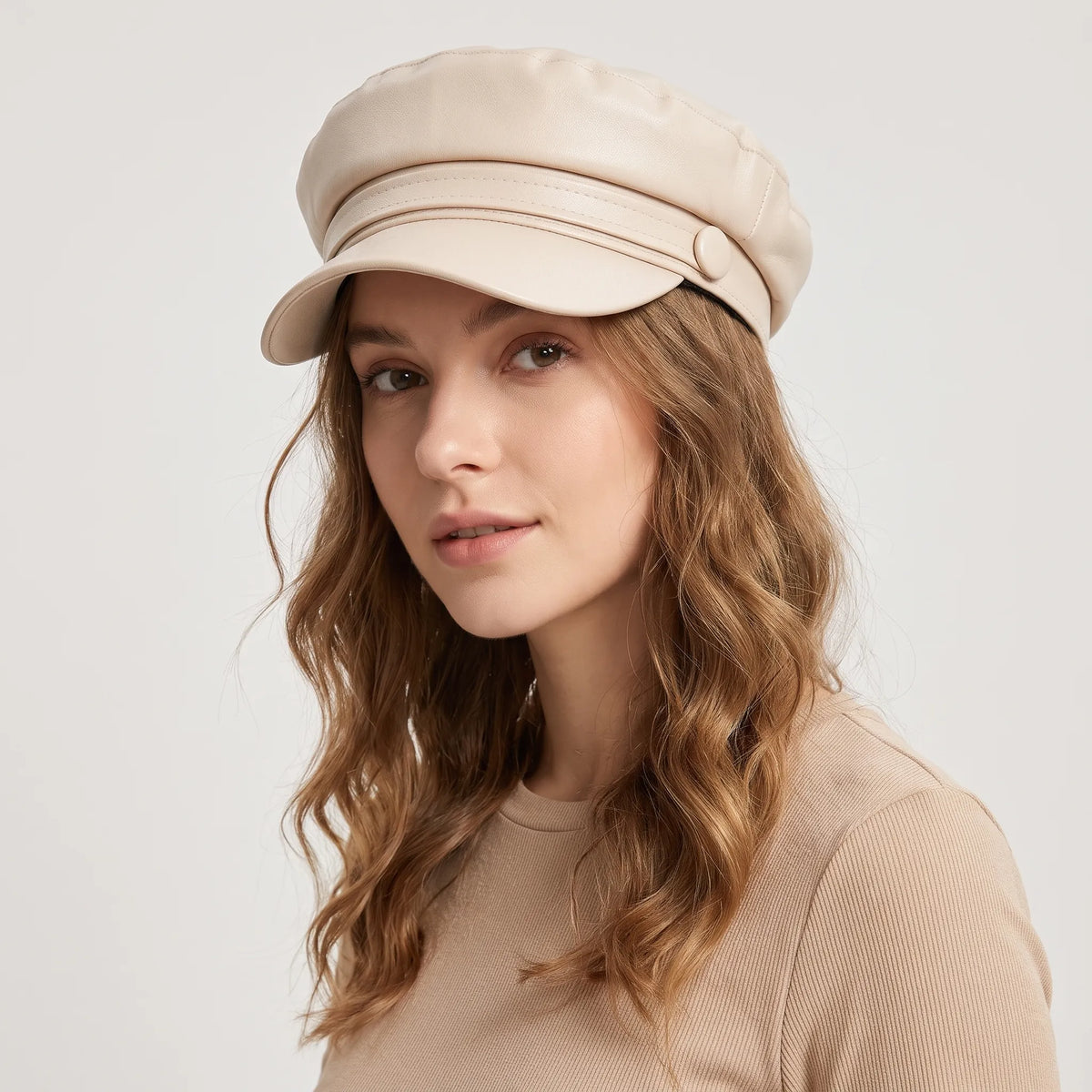 Woman with long wavy hair wearing the cream baker boy hat, looking over her shoulder 19