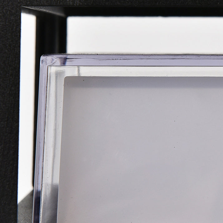 Close-up of the clear protective edge and frosted white diffuser panel of the light, seen behind the black frame. 6