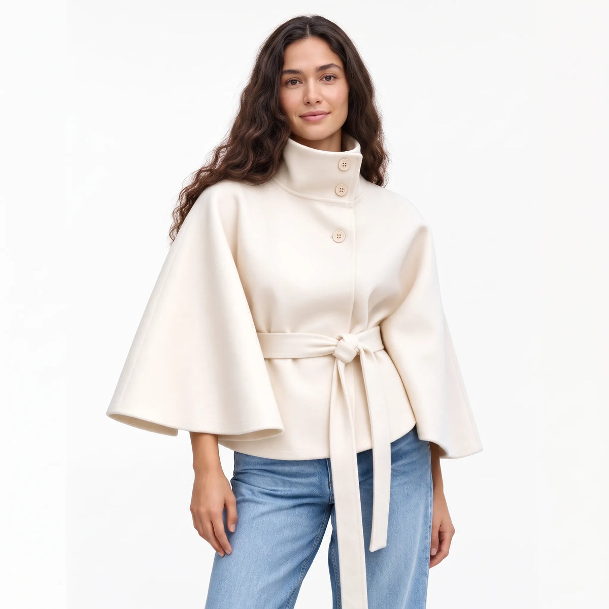 Studio shot of the cream cape jacket with jeans, a knotted belt and wide flared sleeves 19