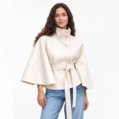 Studio shot of the cream cape jacket with jeans, a knotted belt and wide flared sleeves 19