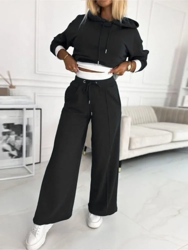 Black cropped hoodie and wide-leg trousers with drawstring waist, white layer visible beneath the hem 19
