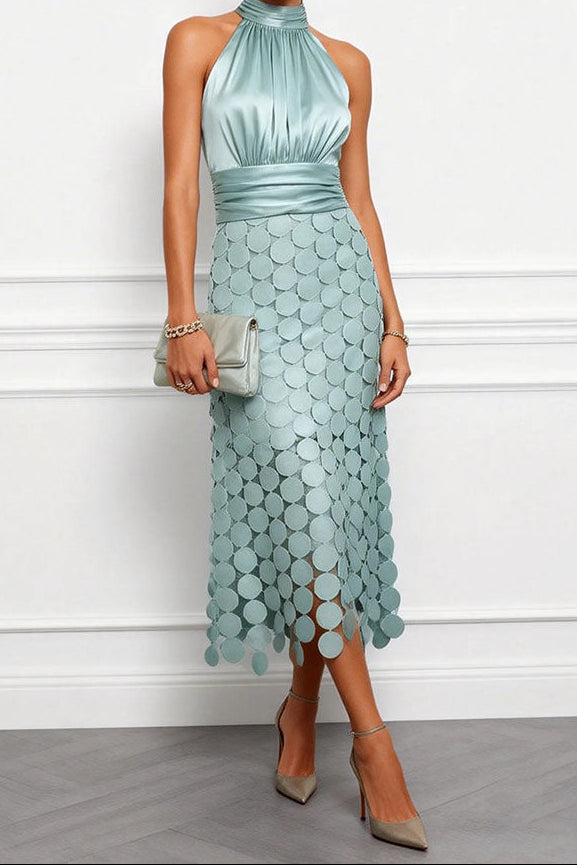 Model wears the halter midi dress in pale sage green with a ruched satin bodice, disc appliqué skirt and a matching clutch. 2