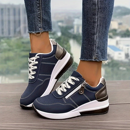 Navy lace-up trainers with side zip and thick white sole, worn with frayed jeans outdoors 1