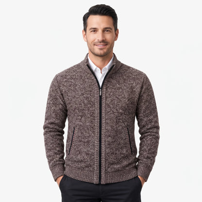 Smiling man models the brown flecked zip cardigan over a white shirt, hands in black trouser pockets 1