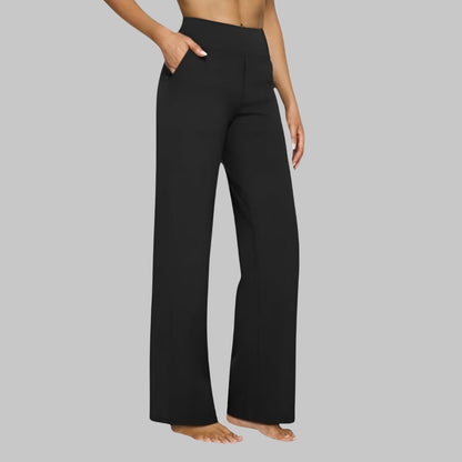 Black version of the high-waist straight-leg trousers, side view of a barefoot model with hand in pocket. 9