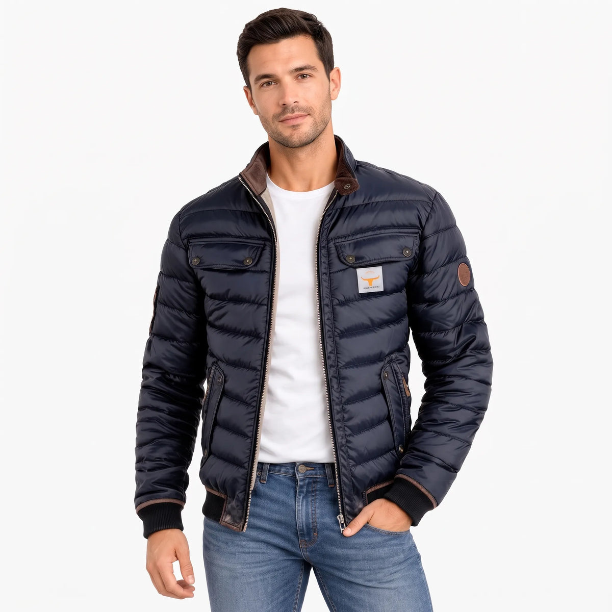 Model wearing the navy quilted jacket unzipped over a white t-shirt and blue jeans, hand in pocket 1